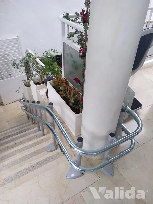 Silla sube escaleras curvas en jardín en Mairena de Aljarafe